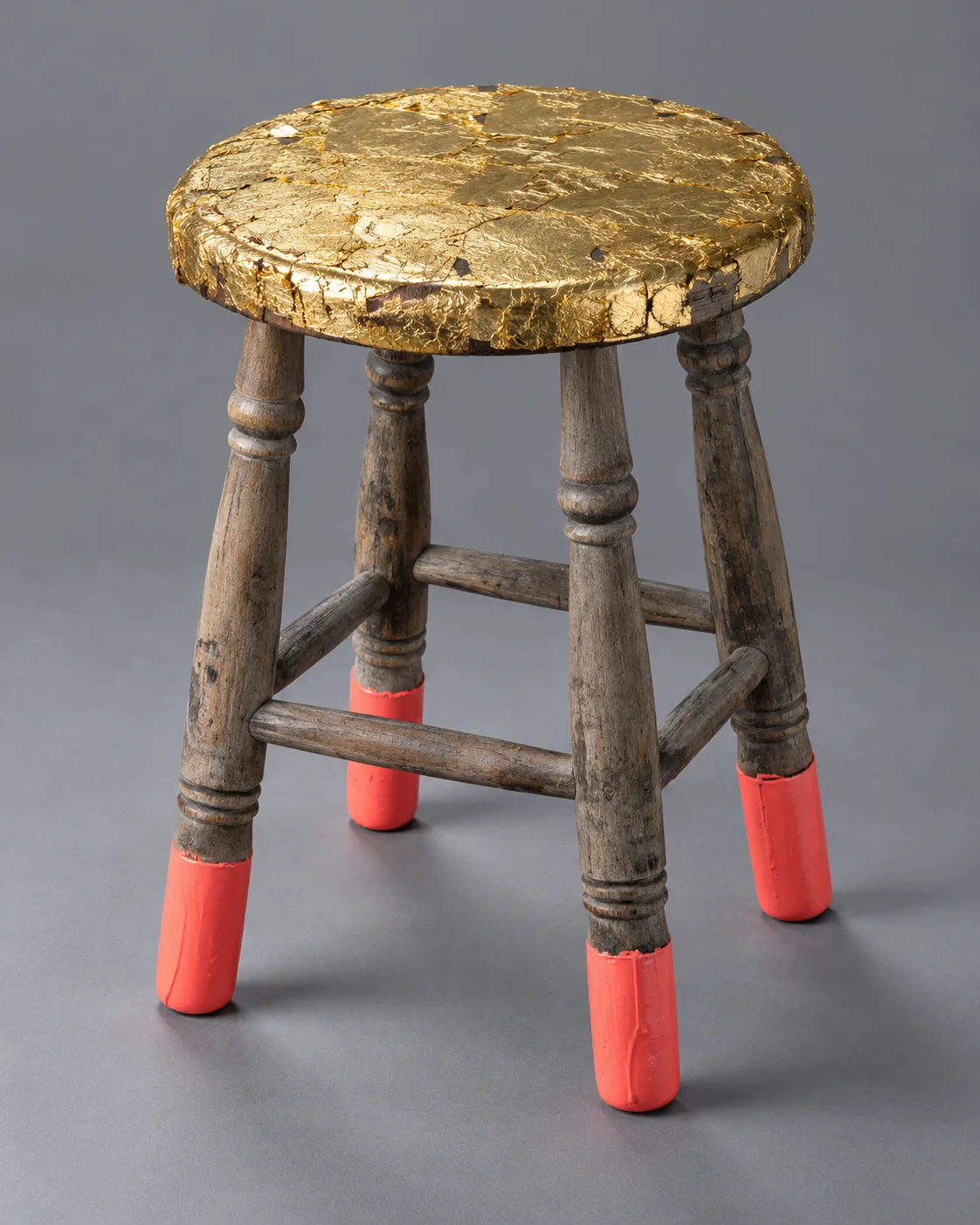 Concept render of a weathered wooden stool with a gold leaf seat and coral-painted feet