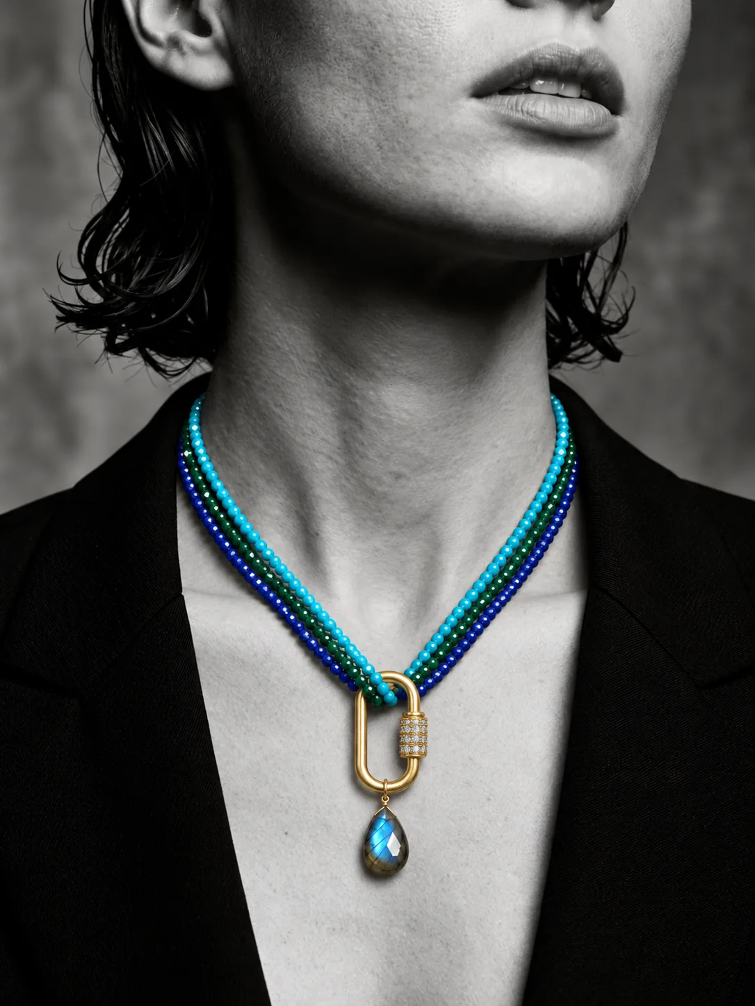 Black and white portrait with turquoise, emerald and lapis strands on a gold carabiner